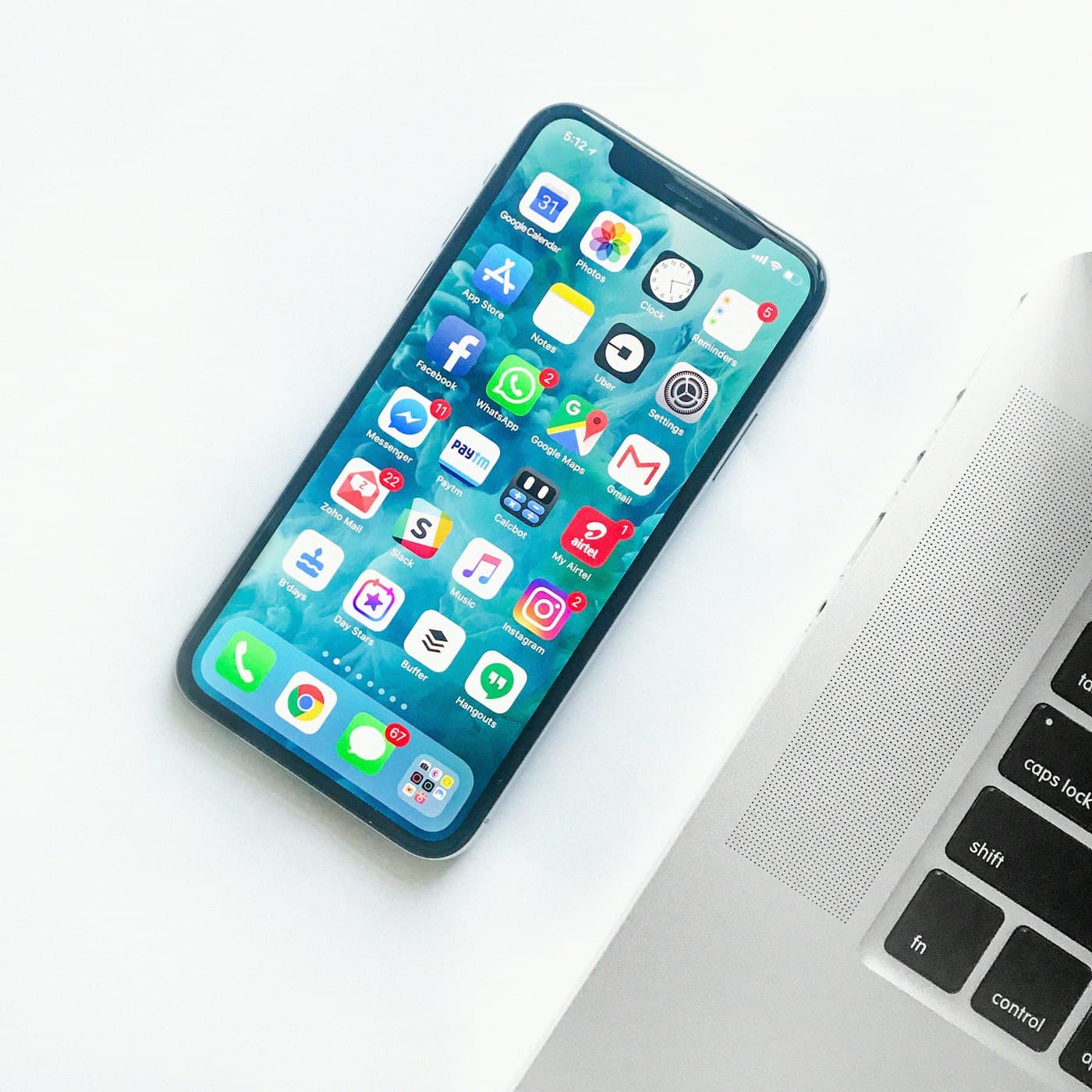 Smartphone met apps naast een laptop